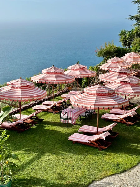 Outdoor patio furniture and umbrellas overlooking the sea